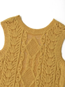 Detaillierte Nahaufnahme des Häkelmusters und der Stricktextur am senfgelben Oberteil