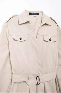 Détail d'une robe chemise beige avec col à revers, ceinture et poches poitrine