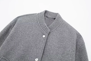 Close-up of grey wool blend bomber jacket featuring rib-knit collar and metal snap buttons