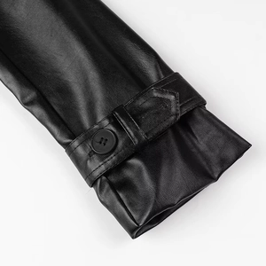 Detailed close-up of a black faux leather jacket sleeve with a buttoned cuff strap