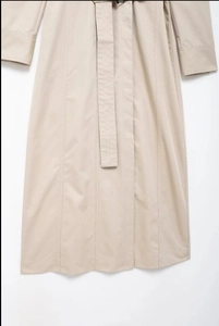 Gros plan détaillé de la ceinture du trench-coat et des boucles de poignets réglables