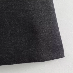 Detailed macro view of dark grey wool fabric texture and thick material on the coat