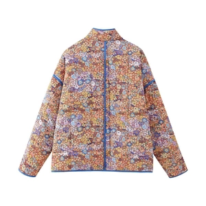 Detail van gewatteerd bloemenjack met vintage print en contrasterende blauwe bies