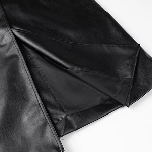 Close-up of split hem on black faux leather coat showing high-quality stitching and lining
