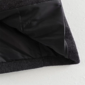 Close-up of high-quality dark grey wool blend fabric with smooth black satin lining