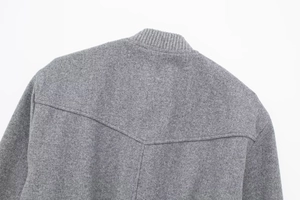 Macro detail of grey wool bomber jacket showing ribbed collar and V-shaped back stitching
