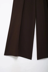 Détail du pantalon large marron chocolat avec un drapé élégant et un ourlet aux finitions nettes