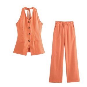 Detail view of coral orange halter waistcoat with buttons and elastic waist wide-leg trousers