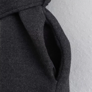 Detailed macro view of dark grey wool fabric showing side pocket and thick texture
