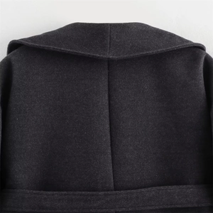 Detailed back view of dark grey wool coat showing high-quality stitching and fabric texture