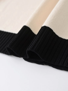 Detailed macro view of cream and black contrast knit texture with ribbed hem finish