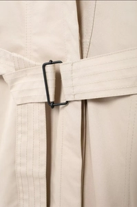 Détail de la ceinture de trench-coat kaki avec une boucle rectangulaire en métal noir mat