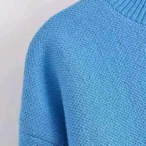 Close-up of vibrant blue knit sweater featuring premium texture and round neckline