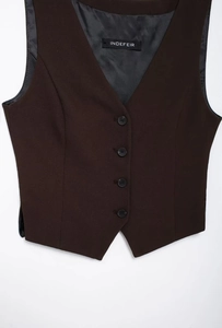 Détail d'un gilet marron foncé avec col en V, quatre boutons noirs et une doublure noire