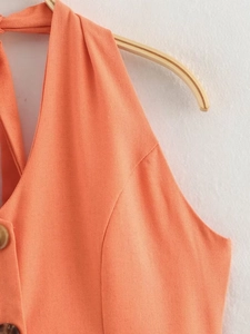 Detailed close-up of orange linen-blend halter top featuring stylish front buttons
