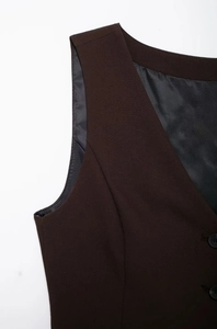 Vue détaillée du gilet marron foncé avec fente latérale et doublure en sergé gris