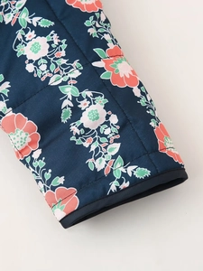 Close-up of floral print quilted jacket cuff with navy blue fabric and pink flower details
