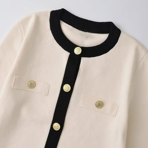 Elegant cream knit cardigan with black contrast trim and decorative gold buttons