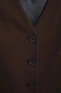 Détail du gilet marron foncé avec col en V, boutons et texture en sergé fine