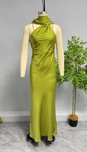 Detail of the grass green satin fabric and halter neckline on a long evening dress
