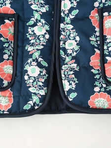 Detail of floral quilted cotton fabric with navy blue base and white red floral pattern