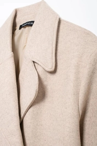 Detailed view of wide lapel and soft wool blend texture on a beige autumn coat