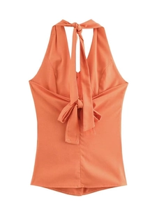 Detail of coral orange halter top featuring an elegant oversized back bow tie design