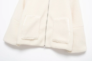 Détail de la veste sherpa blanc cassé avec fermeture éclair et grandes poches