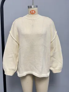 Detail of cream cable-knit sweater showing chunky ribbed texture and high collar design