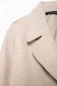 Detail of notch lapel and soft wool texture on women's beige oversized long coat