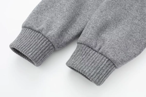 Detailed macro view of the grey rib-knit cuffs on a soft oversized bomber jacket