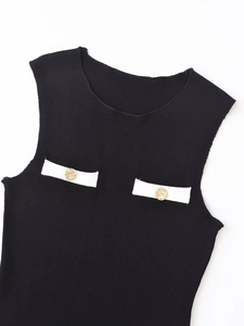 Gros plan détaillé d'une robe tricotée noire sans manches avec poches blanches et boutons