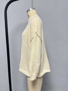 Detail of cream-colored chunky knit sweater with ribbed high neck and drop shoulder