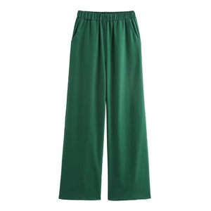 Detail of green wide-leg trousers featuring elastic high waist and side pockets
