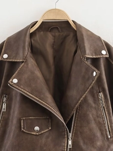 Detail of dark brown biker jacket with retro texture, lapels and silver metal snaps