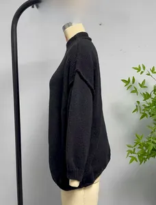 Detail view of black knit sweater with semi-high collar and dropped shoulder on mannequin