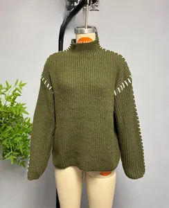 Detail of olive green ribbed knit sweater featuring white contrast hand-stitched shoulder seams
