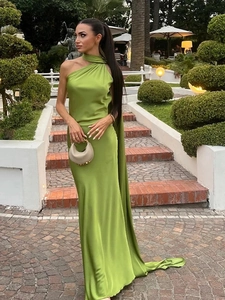 Detail of lime green satin halter gown showing the smooth fabric texture and backless design