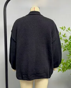 Detail view of the chunky knit pattern on a black loose fit cardigan for women