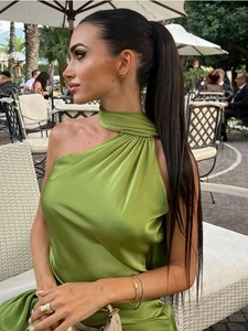 Detail of elegant grass green satin dress with twisted halter neck and silky texture