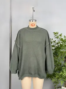 Close-up of sage green knit sweater featuring vertical ribbed texture and mock neck collar