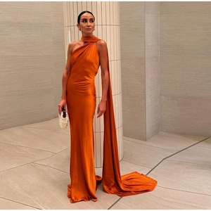 Detail of elegant orange silk halter dress with long sash and floor-length hemline