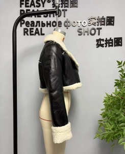 Detail view of women's biker jacket with black leather and white sherpa fleece lining