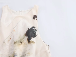 Detail of white sleeveless dress showing centered zipper and abstract ink-splash print