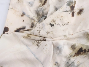 Detail of ruched ivory fabric with abstract brown ink print on sleeveless dress