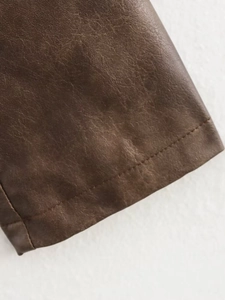 Close-up of deep brown washed leather jacket showing detailed stitching and premium texture