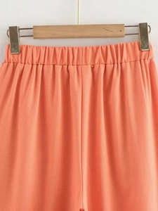 Detail of coral pink textured cotton linen pants featuring a comfortable elastic waistband