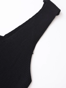 Détail rapproché du tissu en maille côtelée noire et des coutures d'une robe à brepelles