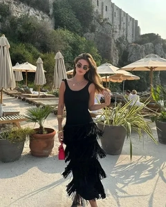 Détail de la robe midi noire sans manches avec de longues franges à plusieurs niveaux