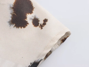 Close-up of high-density fabric texture and rolled hem stitching on printed dress